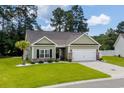 Beautiful one-story home featuring a lush green lawn, brick accents, and a two-car garage at 216 Palm Terrace Loop, Conway, SC 29526