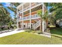 A three-story house featuring a concrete driveway, spacious carport, a three-story porch and ample landscaping at 3304 Palm St., North Myrtle Beach, SC 29582