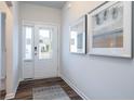 Bright foyer features a glass front door, hardwood floors, and modern artwork at 640 Mccorkle Place, Conway, SC 29526