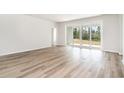Bright living room features wood-look floors and sliding glass doors to the backyard at 893 Ireland Dr., Longs, SC 29568