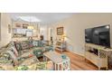 Cozy living room with a floral sofa, tv, and a view into the kitchen at 9501 Shore Dr. # B-224, Myrtle Beach, SC 29572