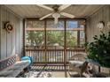 Relaxing screened-in porch with ceiling fan and views of mature trees and the complex parking lot at 9501 Shore Dr. # B-224, Myrtle Beach, SC 29572