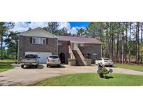 Brick house with a metal roof, double-car garage, and landscaping at 7101 Choppee Rd., Georgetown, SC 29440