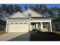 Two-story house with gray siding, a white garage door, and landscaping at 552 Beckham Ct., Murrells Inlet, SC 29576