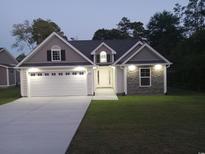 House exterior featuring a two-car garage and stone accents at 1023 Meares St., Calabash, NC 28467