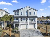 Two-story waterfront home with a gray exterior, two-car garage, and a paved driveway at 1316 Marina Bay Dr., North Myrtle Beach, SC 29582