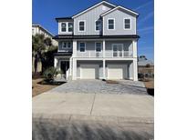 Three-story home with gray siding, white trim, and a three-car garage at 1316 Marina Bay Dr., North Myrtle Beach, SC 29582