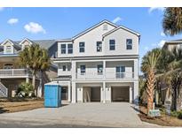 New construction home featuring a three-story exterior with a spacious three-car garage and dual balconies at 410 5Th Ave. S, North Myrtle Beach, SC 29582