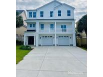Stunning three-story white home with a charming balcony and a spacious two-car garage at 410 5Th Ave. S, North Myrtle Beach, SC 29582