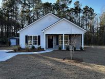 Charming single-story home featuring a symmetrical design, gray brick accents, and a well-manicured front yard at 3157 Bryant St., Loris, SC 29569