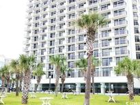 Condo exterior featuring multiple balconies, landscaping and palm trees at 2300 N Ocean Blvd. # 134, Myrtle Beach, SC 29577
