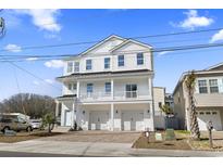 Beautiful, three story home with white siding, a balcony, and a brick driveway at 2401 Duffy St., North Myrtle Beach, SC 29582
