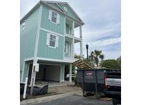 New construction with a two-story covered porch, pale blue siding, white trim and a drive-under garage at 1207 Salt Windy Way, North Myrtle Beach, SC 29582