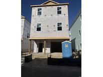 New home under construction with visible framing and Tyvek wrap showcasing the structure's progress and design at 1310 Battery Park Dr., North Myrtle Beach, SC 29582