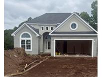 New construction home featuring a modern design with a gray stucco finish, arched window, and open garage at 5508 Via Verde Dr., North Myrtle Beach, SC 29582