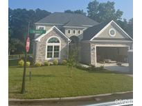 Two-story home featuring stone accents, attached garage, and manicured front lawn at 5508 Via Verde Dr., North Myrtle Beach, SC 29582