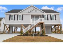 Inviting coastal home featuring elevated design, black shutters, and a welcoming staircase at 2731 South Bay St., Georgetown, SC 29440
