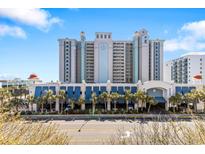 Beautiful condo building with underground parking, blue facade, and palm tree lined entrance at 2401 S Ocean Blvd. # 1156, Myrtle Beach, SC 29577