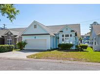 Charming light blue single story home with well-maintained lawn, attached garage and neatly trimmed landscaping at 2729 S Key Largo Circle, Myrtle Beach, SC 29577