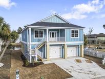 Charming raised beach home with a two-car garage and inviting staircase to a cozy porch at 2307 Tortuga Ln., North Myrtle Beach, SC 29582