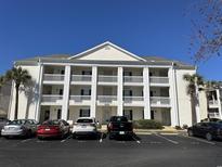Attractive building with white pillars and ample parking on a clear, sunny day at 5020 Windsor Green Way # 103, Myrtle Beach, SC 29579