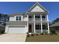 Charming two-story home with a double porch, white siding, and a well-manicured lawn at 120 Fair Meadow Ct., Loris, SC 29569
