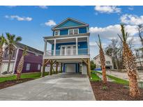 Charming blue two-story home with a covered porch, spacious driveway, and lush landscaping at 723 10Th Ave. S, Surfside Beach, SC 29575