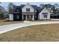 Two-story farmhouse with black and white exterior, metal roof, and large driveway at 206 Green Lake Dr., Myrtle Beach, SC 29572