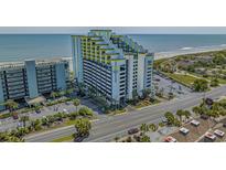 Coastal condo building featuring a unique yellow and white design with ocean views and a parking garage at 6804 N Ocean Blvd. # 1037, Myrtle Beach, SC 29572
