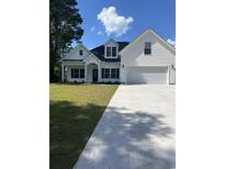 Charming new construction home with a white exterior, black shutters, and an attached two-car garage at Tbd 10 Privetts Rd., Conway, SC 29526