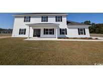 Charming two-story home with a well-manicured lawn, featuring white siding and a welcoming front porch at Tbd 9 Privetts Rd., Conway, SC 29526