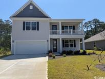 Charming two-story home featuring a covered porch, a two-car garage, and professional landscaping at 121 Fair Meadow Ct., Loris, SC 29569
