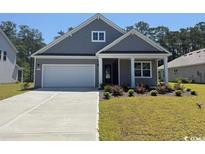 Charming single-story home showcasing a manicured lawn, neutral siding, and an attached two-car garage at 125 Fair Meadow Ct., Loris, SC 29569