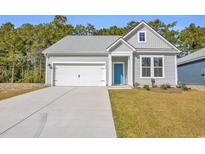 Charming single-story home featuring a bright blue door, gray siding, and a well-maintained front yard at 397 Sun Colony Blvd., Longs, SC 29568