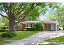 Charming single-story home features a well-manicured lawn, mature trees, and a welcoming brick facade at 660 Cardinal Ave. # 660, Myrtle Beach, SC 29577