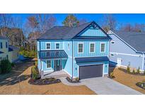 Beautiful two-story blue home with a dark gray roof, lush landscaping, and a two-car garage at 2226 Yellow Morel Way, Myrtle Beach, SC 29579