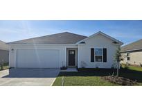 Charming single-story home featuring an attached two-car garage and nicely landscaped front yard at 3850 Lady Bug Dr., Shallotte, NC 28470