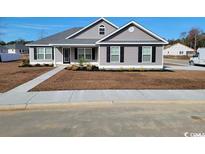 Charming single-story home featuring gray siding, black shutters, manicured lawn, and a welcoming front porch at Tbd12 Privetts Rd., Conway, SC 29526