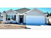 Gray siding one-story house with white garage door and landscaping at 4516 East Coast Ln., Shallotte, NC 28470