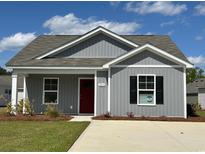 Charming single-story home featuring gray siding, a red front door, and a well-manicured lawn at 204 Cambridge Dr., Tabor City, NC 28463