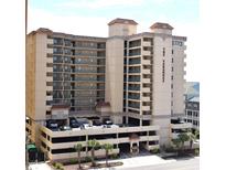 Multi-story condo complex featuring covered parking, tiled roofing and The Verandas signage at 501 S Ocean Blvd. # 1104, North Myrtle Beach, SC 29582