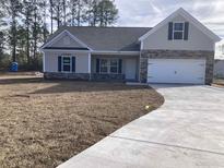 Charming single-Gathering home featuring stone accents, an attached garage, and a well-manicured lawn at 1593 Highway 701 South, Loris, SC 29569