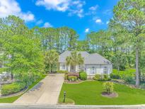 Charming single-story home with mature landscaping, a well-manicured lawn, and a long driveway at 5303 Pheasant Dr., North Myrtle Beach, SC 29582
