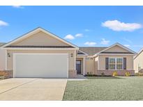 Tan house with gray roof, attached garage, and landscaped lawn at 719 Woodside Dr., Conway, SC 29526