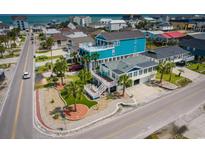 Stunning coastal home featuring vibrant colors, lush landscaping, and multiple decks for enjoying ocean views at 526 Dogwood Dr. N, Garden City Beach, SC 29576
