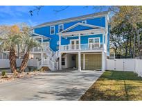 Bright blue two-story home featuring a concrete driveway, white stairs, and lovely porch at 514 Vista Dr., Murrells Inlet, SC 29576