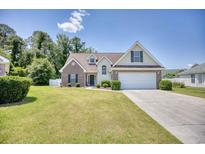 Charming two-story home with brick accents, manicured lawn, and a two-car garage on a sunny day at 2513 Hunters Trail, Myrtle Beach, SC 29588