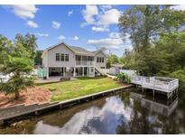 Beautiful canal-front home with a large deck, waterside dock and a well-manicured lawn at 615 N 17Th Ave. N, Surfside Beach, SC 29575