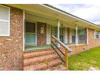 Brick ranch house with a front porch, steps, and white shutters at 705 White Oak Dr., Johnsonville, SC 29555