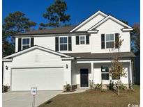 Two-story house with white siding, a two-car garage, and landscaping at 1327 Winding Creek Way, Myrtle Beach, SC 29588